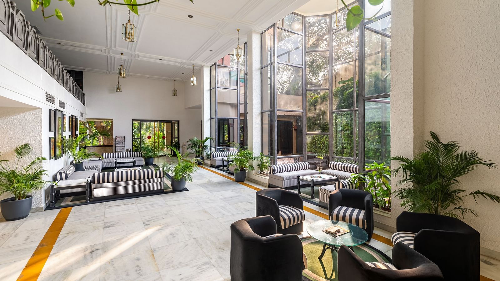 An overview of the lobby of our hotel in Udaipur with seating arrangements and plants in view - Hotel Rajdarshan, Udaipur.