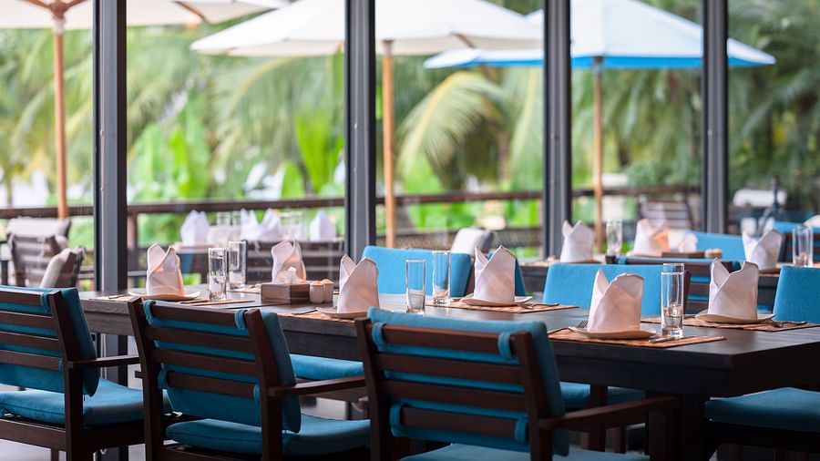 A sitting area with tables and chairs  - Alibu Resorts Nha Trang