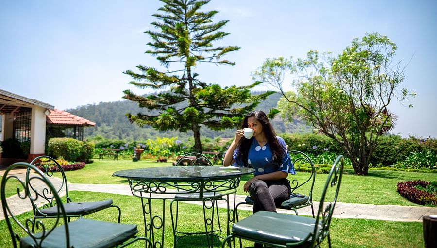 a woman drinking coffee in a garden