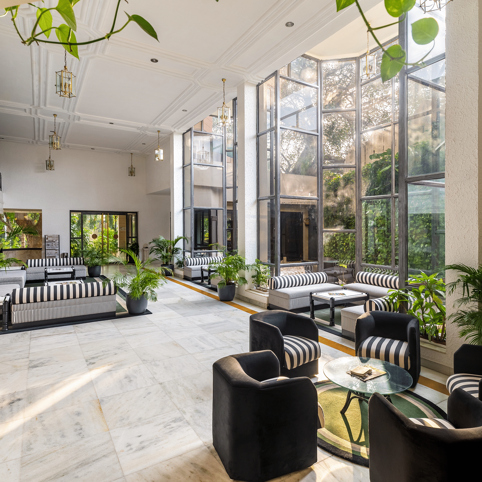 An overview of the lobby of our hotel in Udaipur with seating arrangements and plants in view - Hotel Rajdarshan, Udaipur.