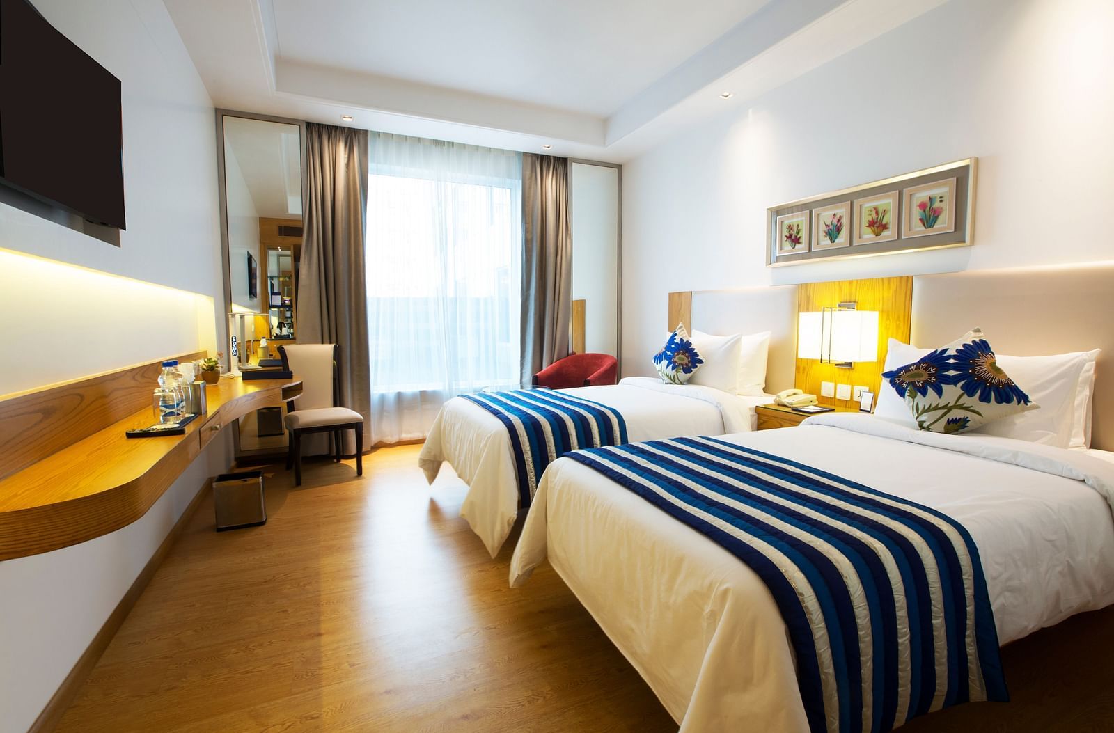 A brightly lit room featuring two single beds with a huge window in the end of the room - Ramada by Wyndham, Ghaziabad, Vasundhara