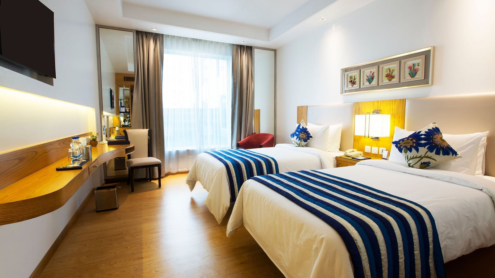 A brightly lit room featuring two single beds with a huge window in the end of the room - Ramada by Wyndham, Ghaziabad, Vasundhara