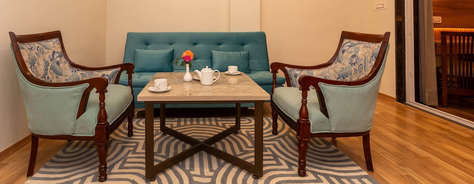 An image of a Family Room with sofa set, centre table, and a rug - The Belvedere Himalayan Retreat, McLeodganj