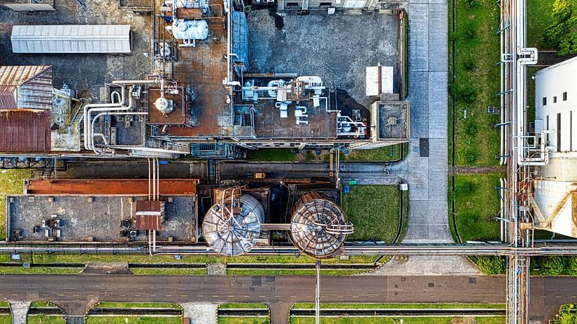 An aerial view shows a sprawling industrial complex with various buildings, roads, and machinery.