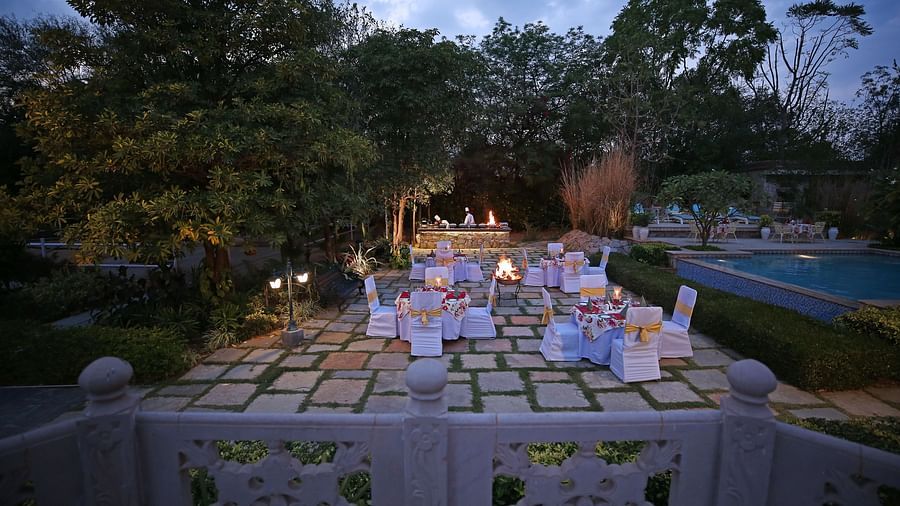 A beautifully arranged outdoor dining table under the evening sky, ready for a grand dinner - Khas Bagh, Jaipur.