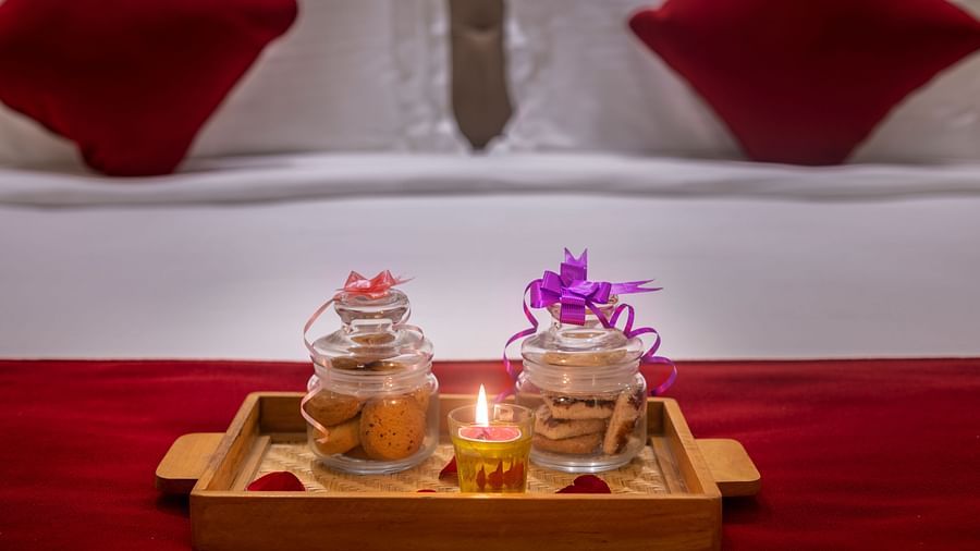 Welcome tray on bed with refreshments and decorative flowers arranged neatly - Lords Eco Inn Shapar Rajkot