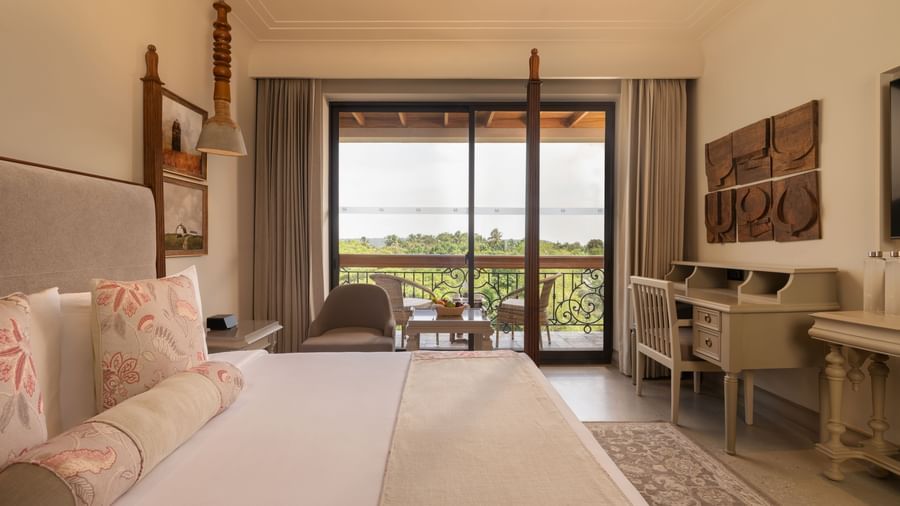 Side view of the Classic Room (Diwa) at The Evren, Vagator, featuring a beautiful balcony overlooking the lush green views.