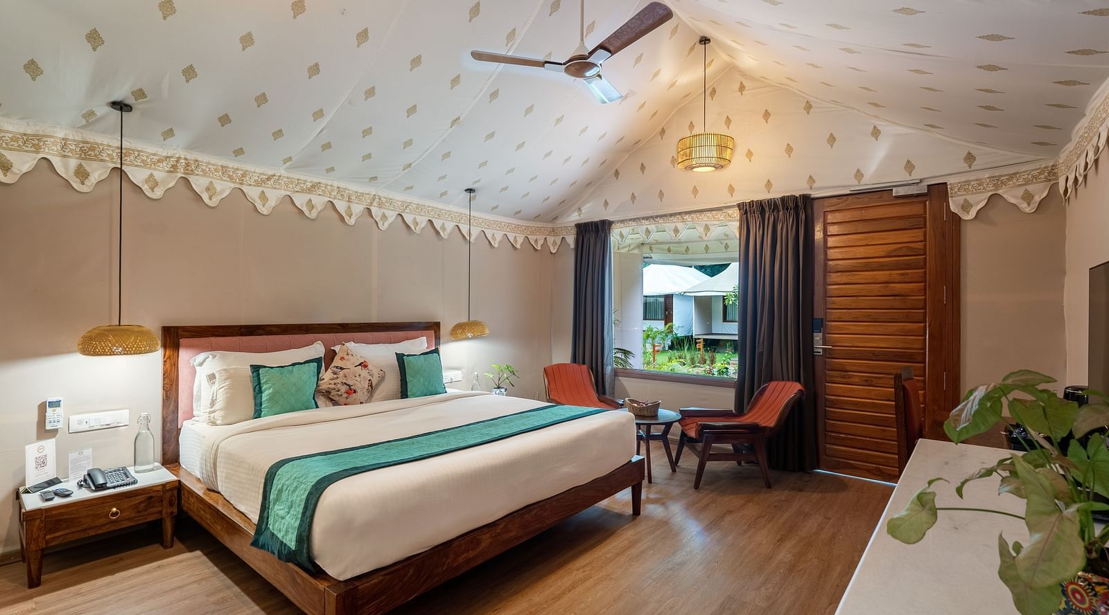 full view of the luxury tent villa with a king size bed and a family seating area in the room