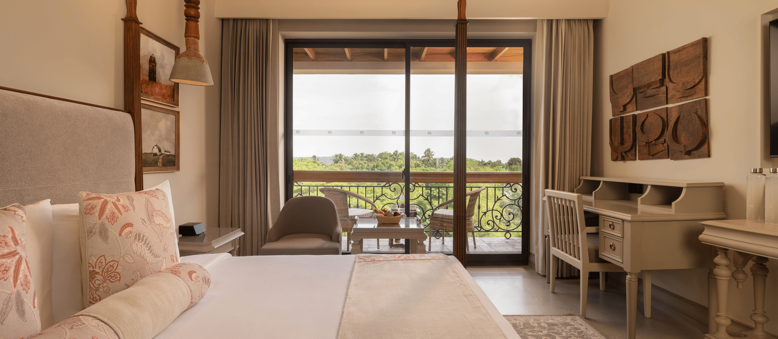 Side view of the Classic Room (Diwa) at The Evren, Vagator, featuring a beautiful balcony overlooking the lush green views.