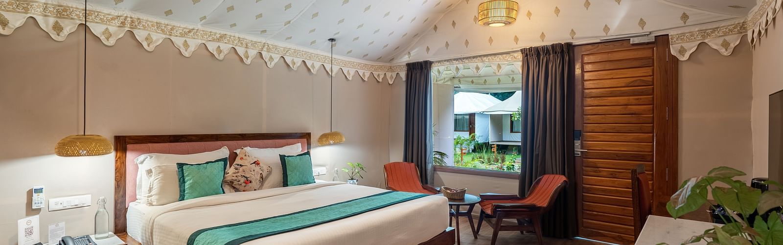 full view of the luxury tent villa with a king size bed and a family seating area in the room