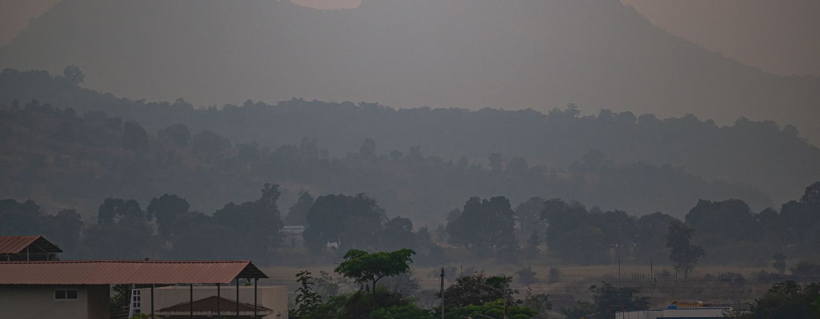 A misty landscape with prominent hills under an overcast sky at Lotus Leaf Boutique Hotel.
