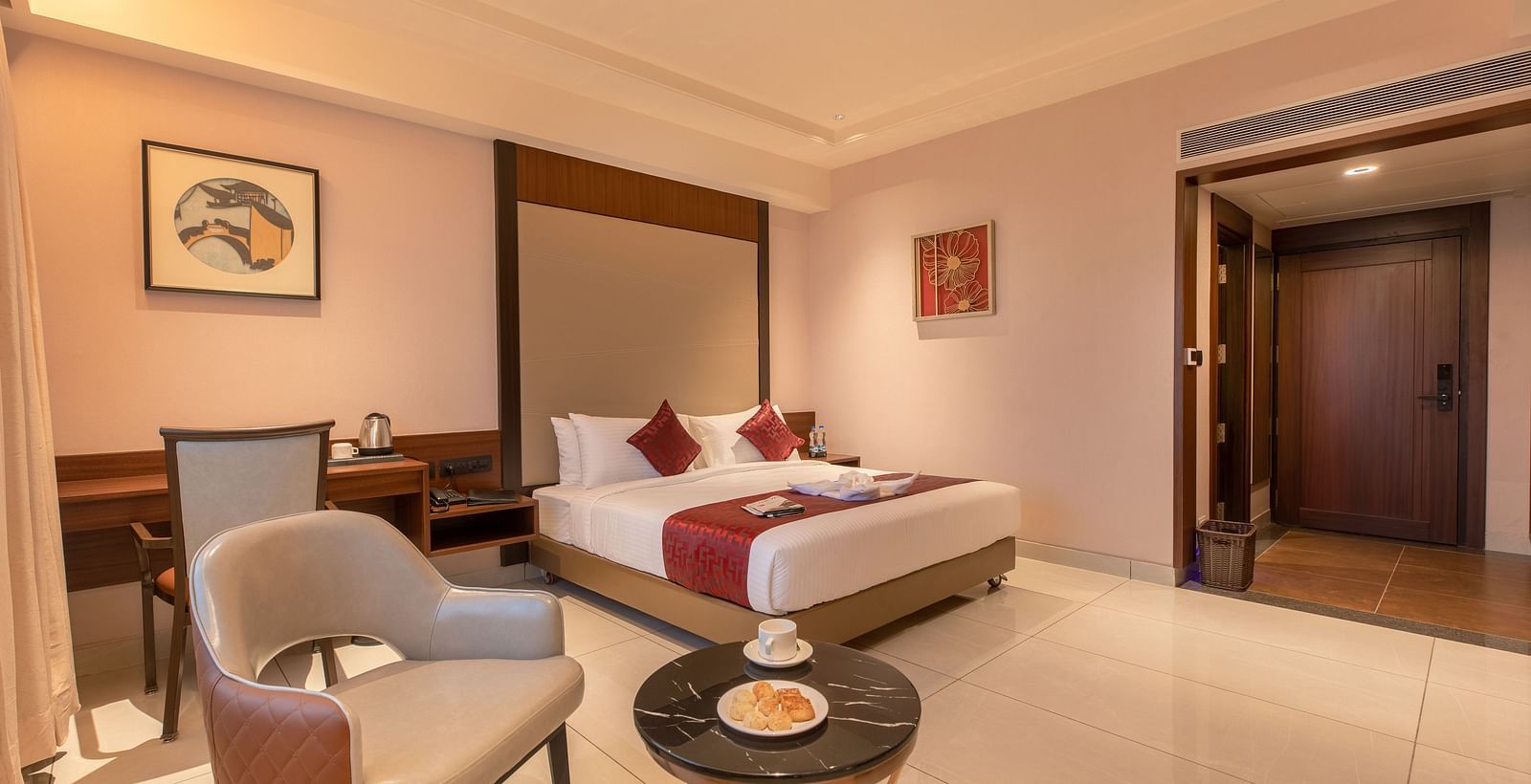 An image of a room featuring a bed, a study area beside it, and a chair with a table at M Pro Palace.