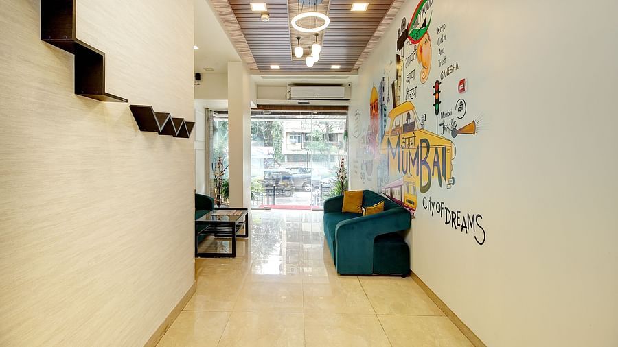 A vibrant lobby with a colorful mural wall representing Mumbai, plush sofas, and a front desk.