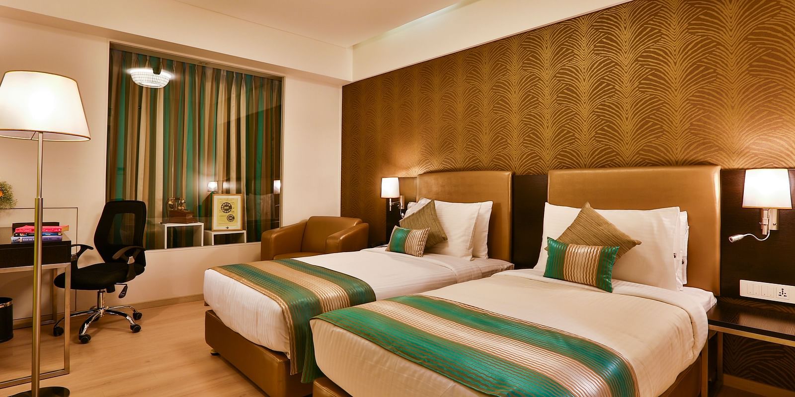 A room with twin beds, a standing desk and a work desk and chair at T24 Residency, Andheri East, Mumbai