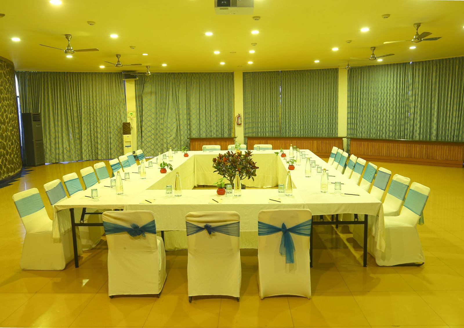 An image of the meeting hall with seating arrangement, bright lighting, and the amenities required for meetings - Great Trails Yercaud by GRT Hotels