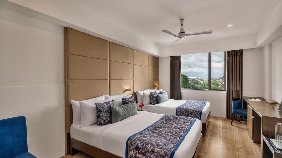 Guest room with twin beds and seating at Voyage Milestone Hotel and Banquet.