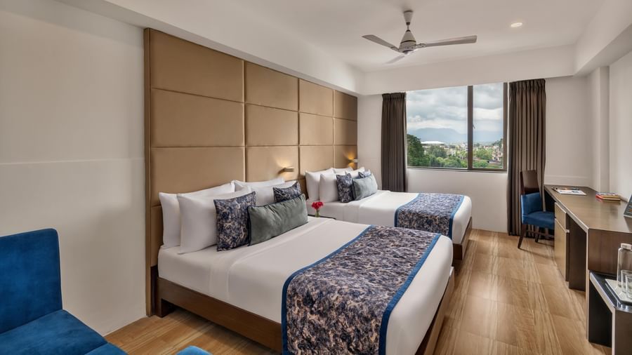Guest room with twin beds and seating at Voyage Milestone Hotel and Banquet.