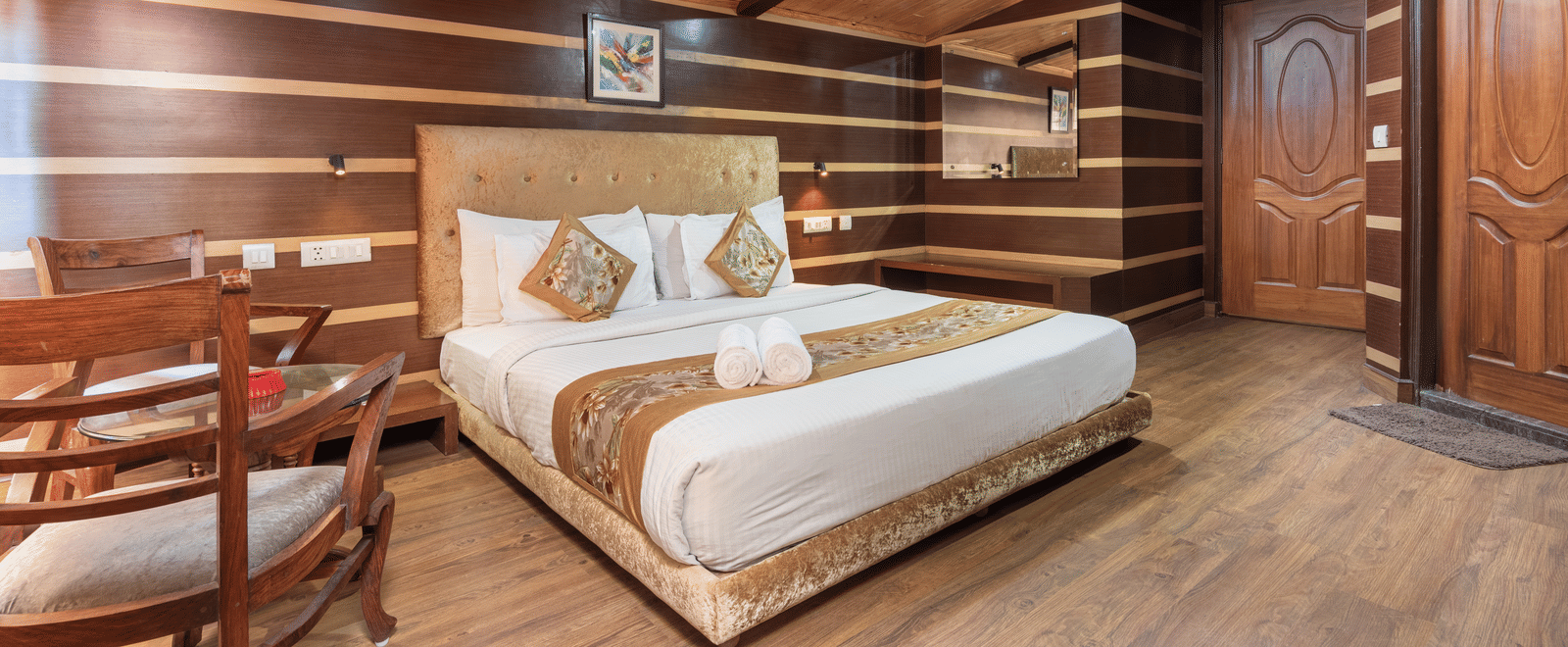 Super Deluxe Room with a king size bed and wooden finished flooring at DLS Hotels The Rock Castle.