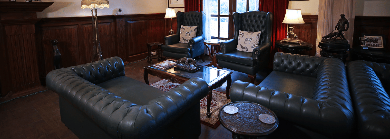 A vintage-style lounge area with elegant leather sofas and decor - Khas Bagh, Jaipur.