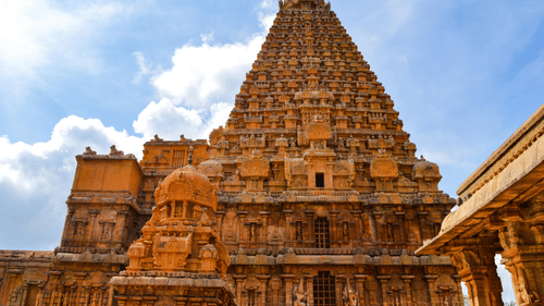 A low-angle view of the towering stone vimana (pyramid structure) of the Brihadeeswarar Temple in Thanjavur.