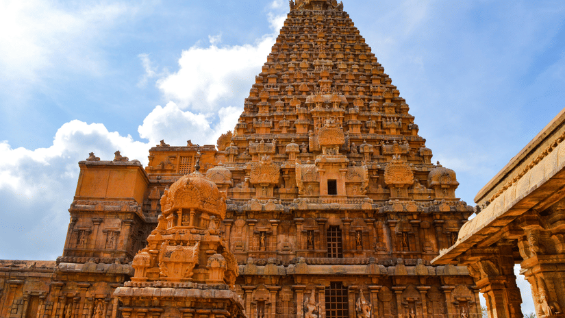 A low-angle view of the towering stone vimana (pyramid structure) of the Brihadeeswarar Temple in Thanjavur.