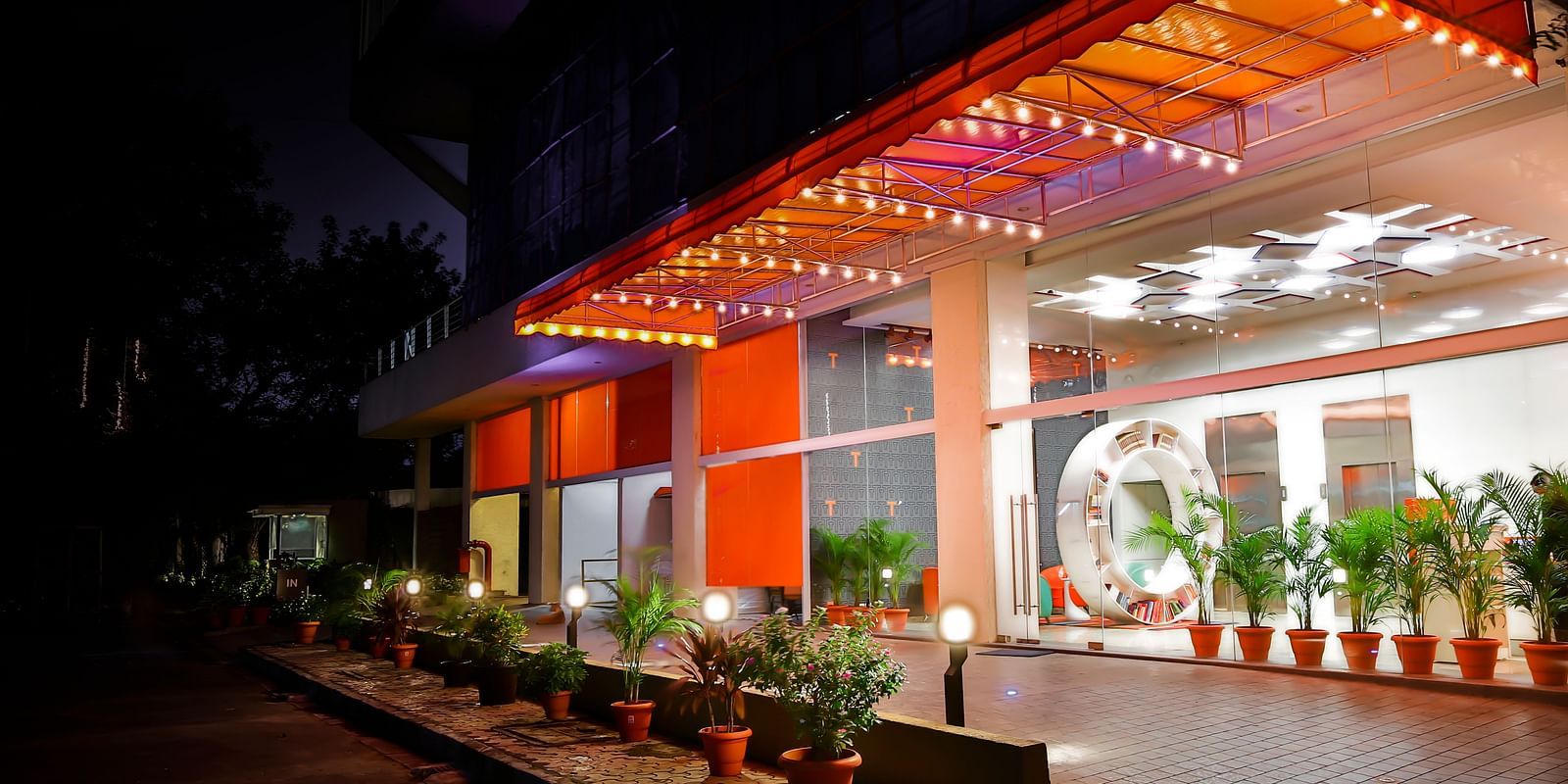 A paved entry way leading to the entrance of T24 Residency, Andheri East, Mumbai with potted plants lining the pavement