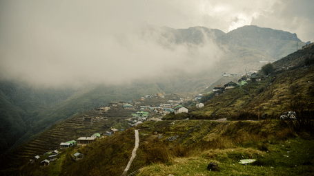 An image of a mountain village surrounded by clouds .