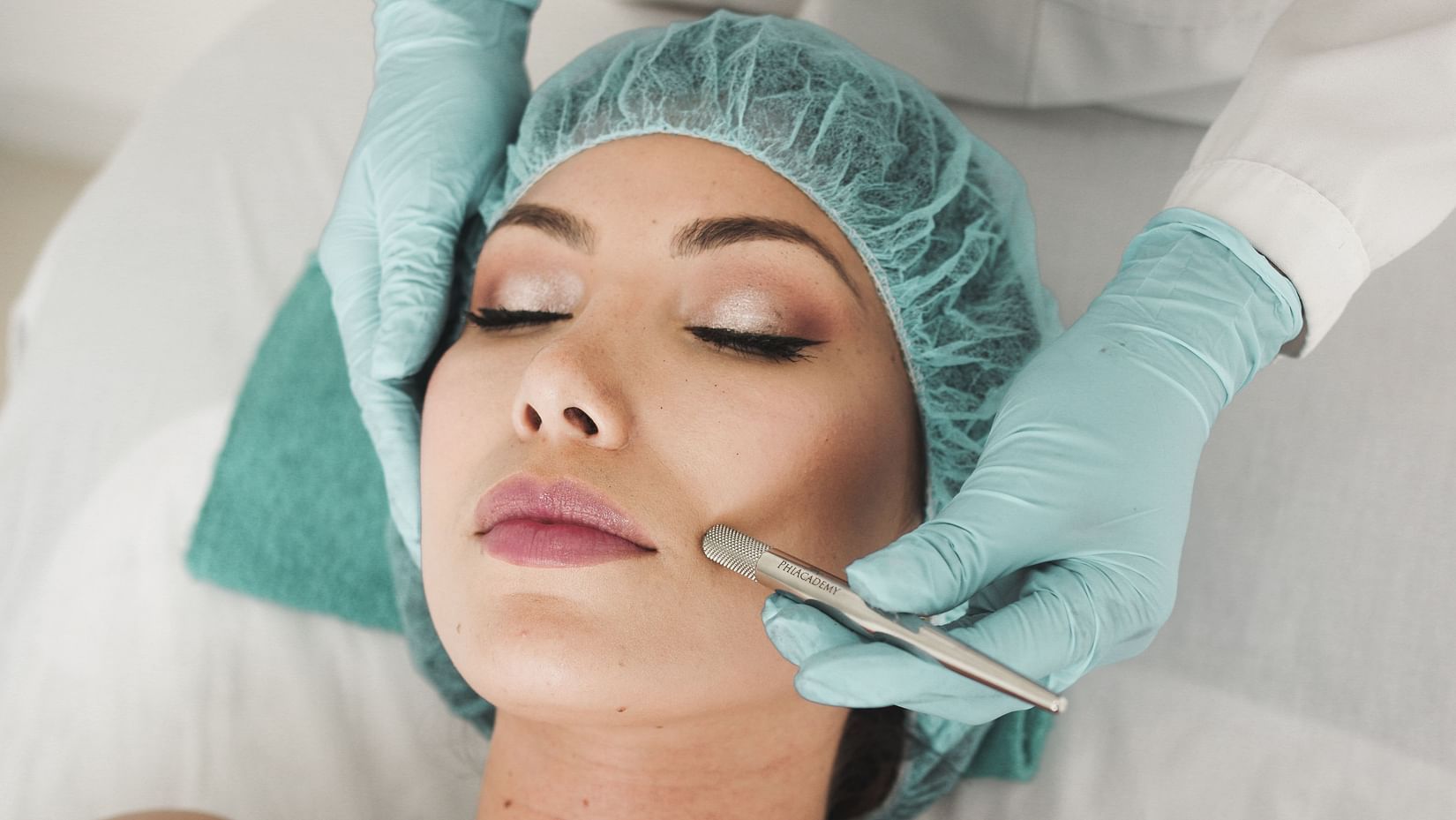 A woman receiving a facial massage from a therapist.