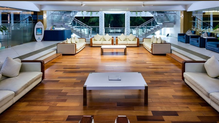 A luxurious hotel lounge area with cream-colored sofas and large windows offering an outdoor view | Grand Bay Resort and Spa