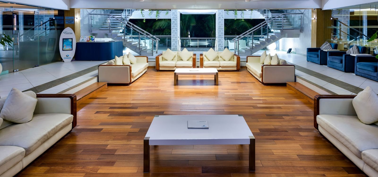 A luxurious hotel lounge area with cream-colored sofas and large windows offering an outdoor view | Grand Bay Resort and Spa