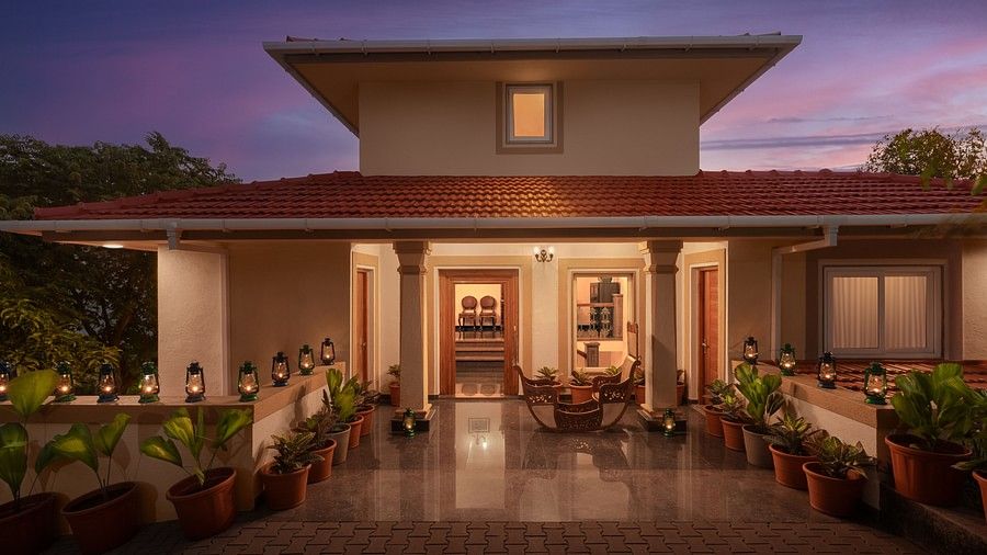The entrance our stay in Sindhudurg featuring orange lights and potted plants - Highland Sarovar Portico, Sindhudurg