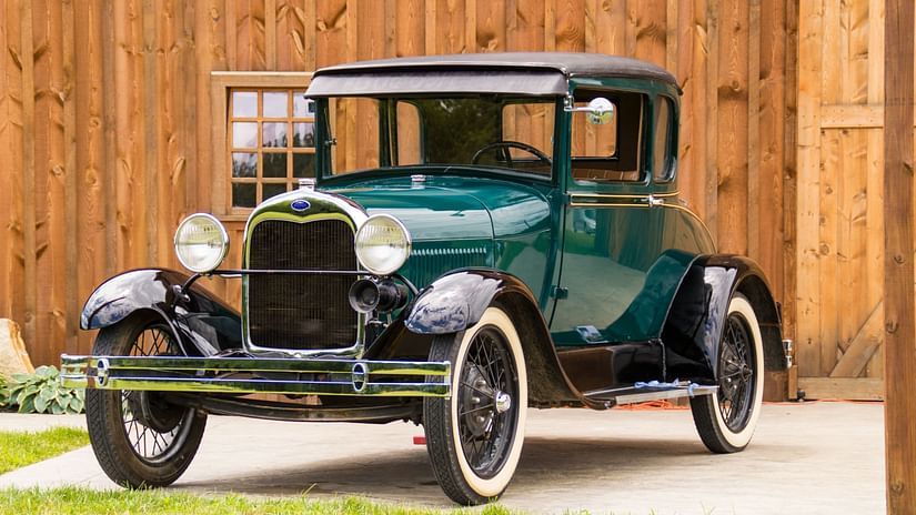 a blue green vintage car parked in place