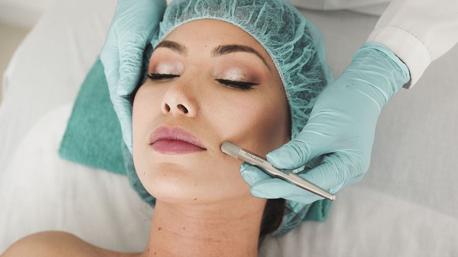 A woman receiving a facial massage from a therapist.