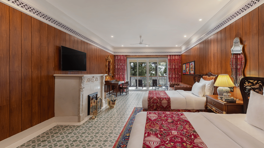 Spacious heritage suite with twin beds, fireplace, and balcony access at Mayfair Manor, Jungpana.