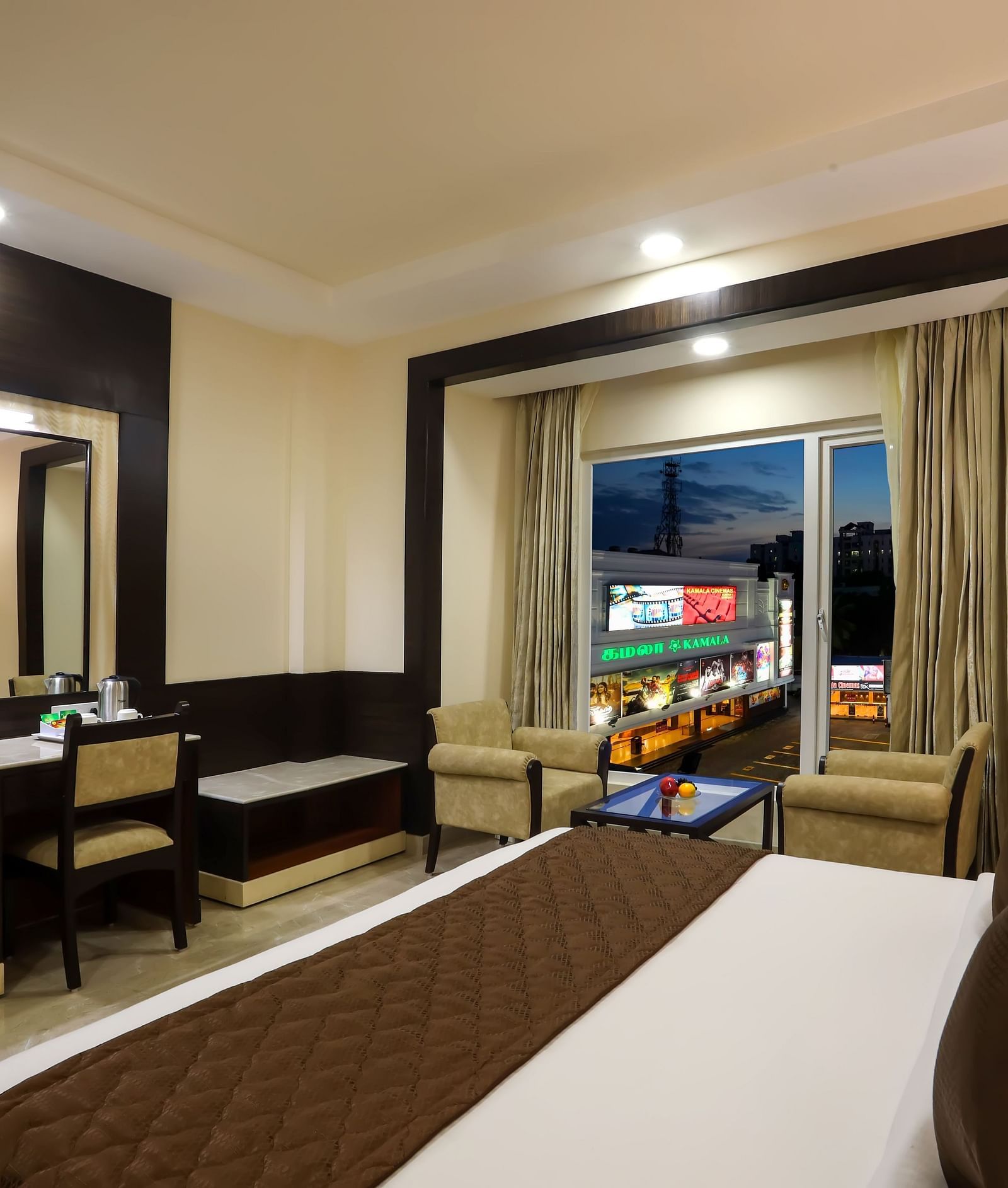 View of a Business Suite with a double bed facing a mirror and a work desk at Hotel Aadithya, Chennai