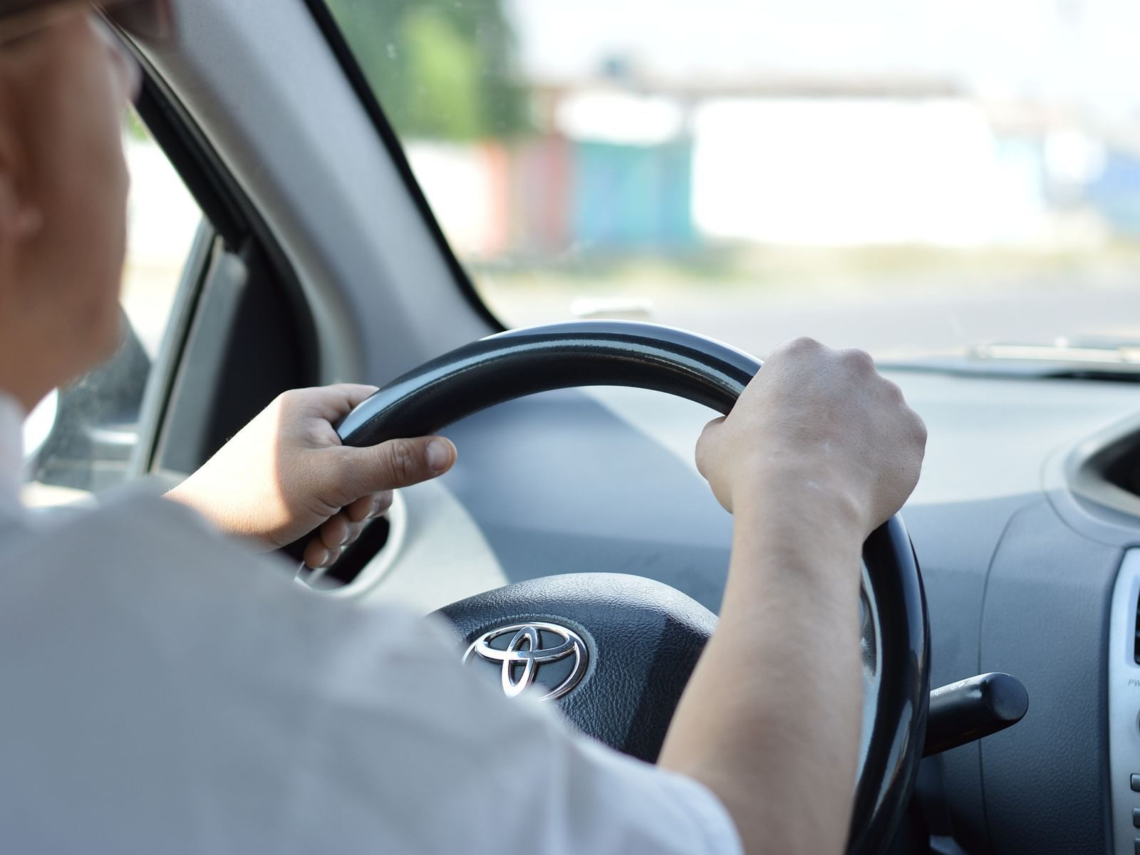 A driver driving the car with his hands on the steering - Wyt Hotels Transit Nest