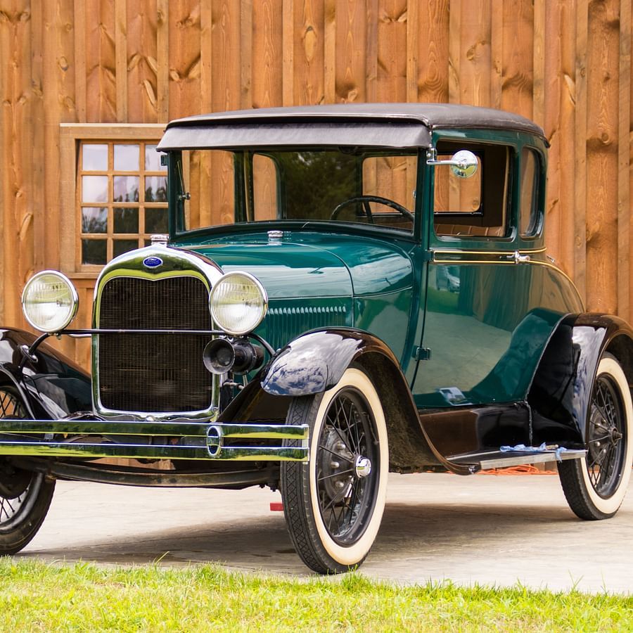 a blue green vintage car parked in place