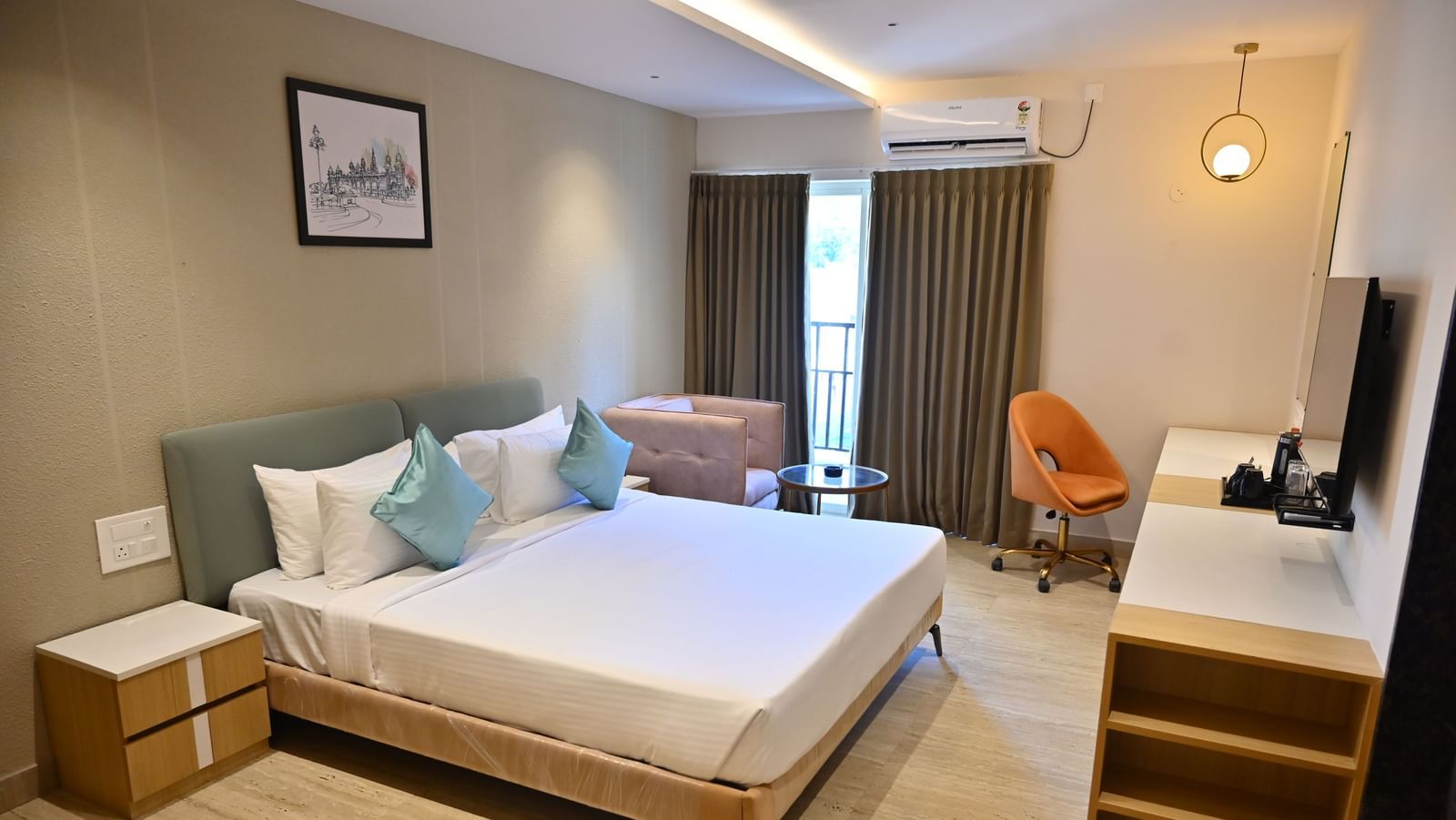 Bright and airy premium room with a big bed, soft chairs, and curtains over large windows, offering plenty of light and modern features at TGI Livancia Hillside