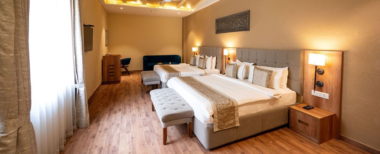 Studio quad bed room at Essentia Luxury Resort & Spa, Udaipur with modern interiors and a window with good lighting.