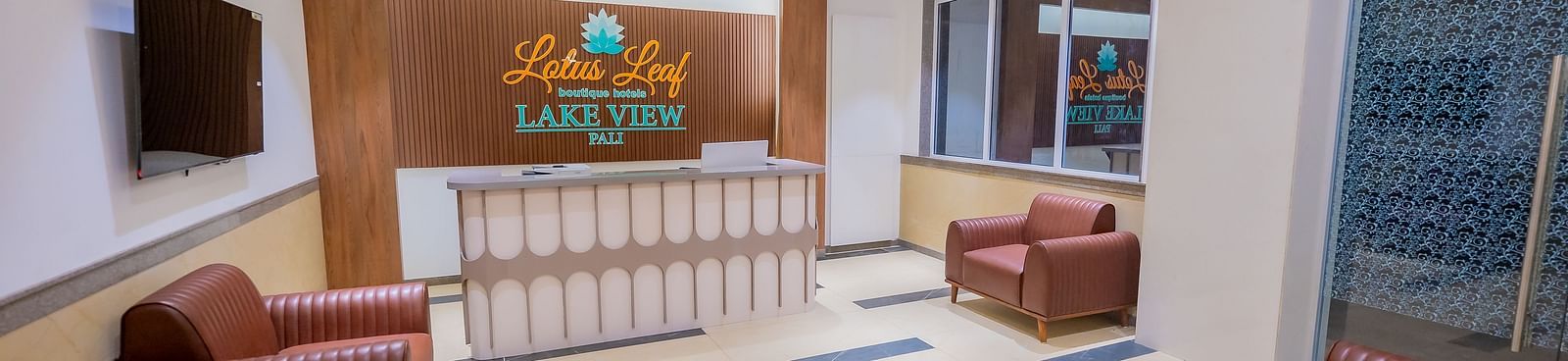 A modern hotel reception area with comfortable seating, a counter, and stylish decor.