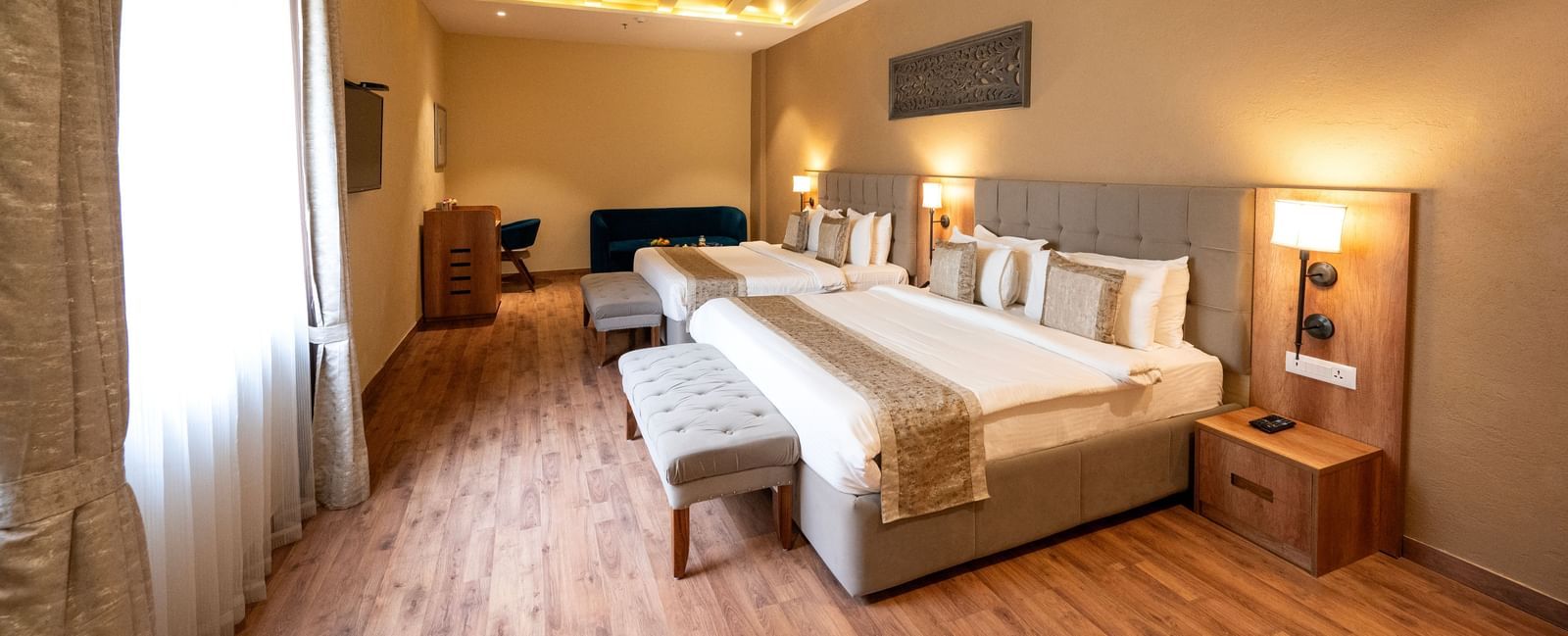 Studio quad bed room at Essentia Luxury Resort & Spa, Udaipur with modern interiors and a window with good lighting.
