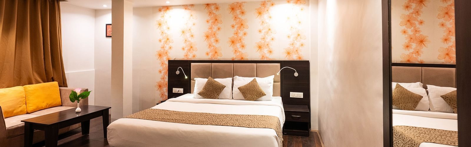 A bedroom with a seating arrangement beside it, and a curtain drawn over the window at Avianna Hungry Jack, Gangtok.