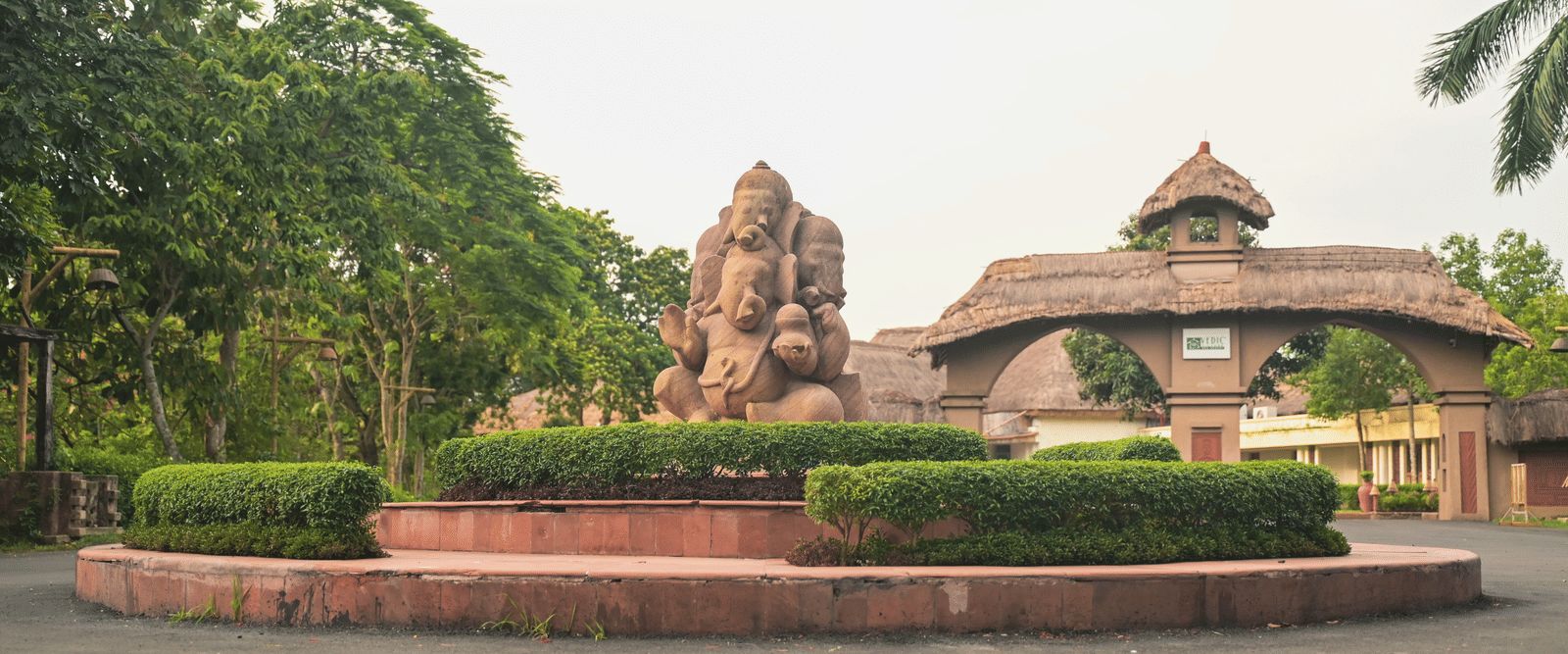 The entrance to Vedic Village Spa Resort featuring a mud sculpture and clay arch ways leading to the property.