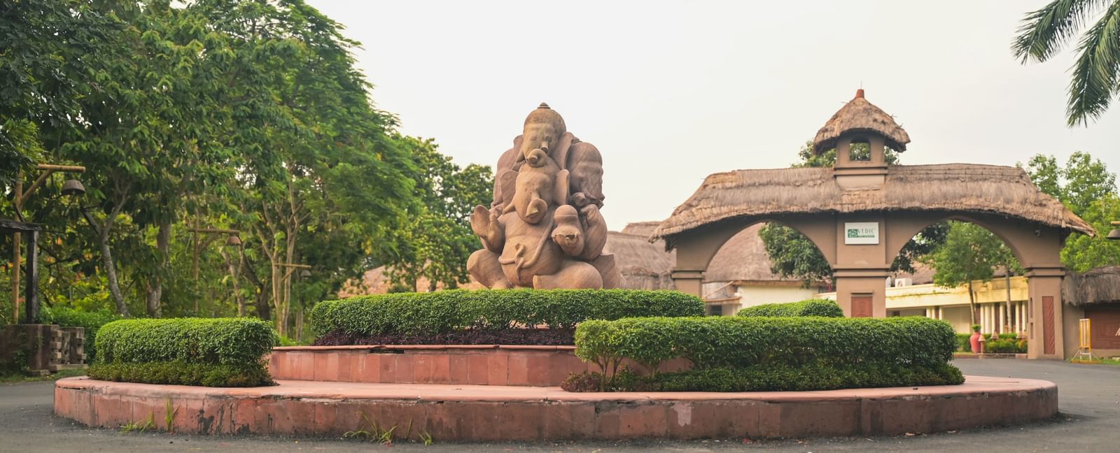 The entrance to Vedic Village Spa Resort featuring a mud sculpture and clay arch ways leading to the property.