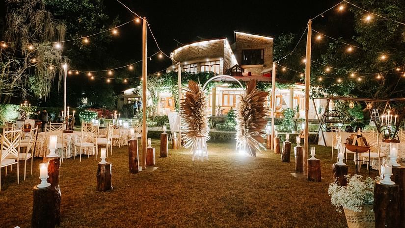 Outdoor wedding reception with hanging lights and festive decorations