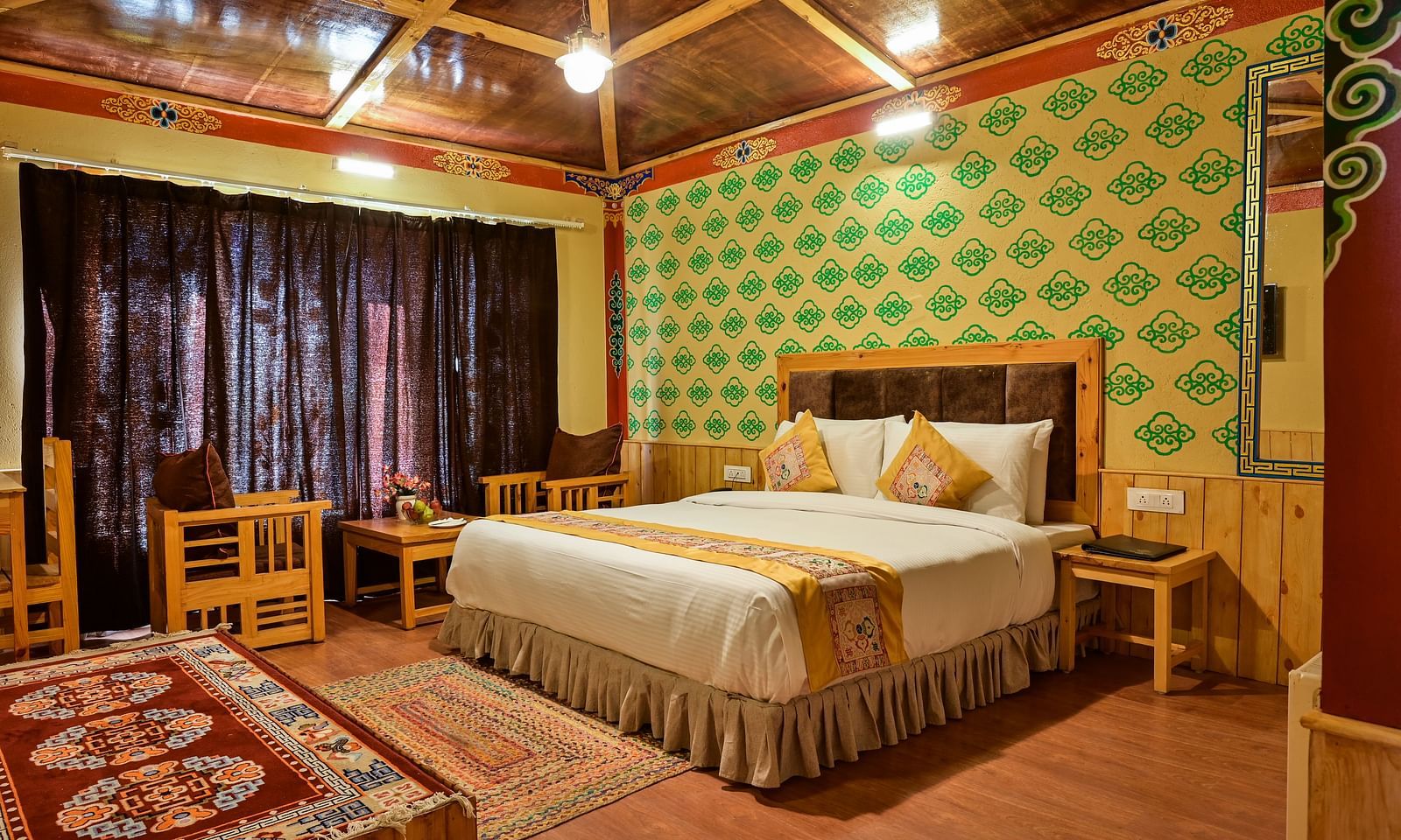Premium Cottage at White Sands Resort, Ladakh, is decorated with patterned carpets and includes a bed and seating area.
