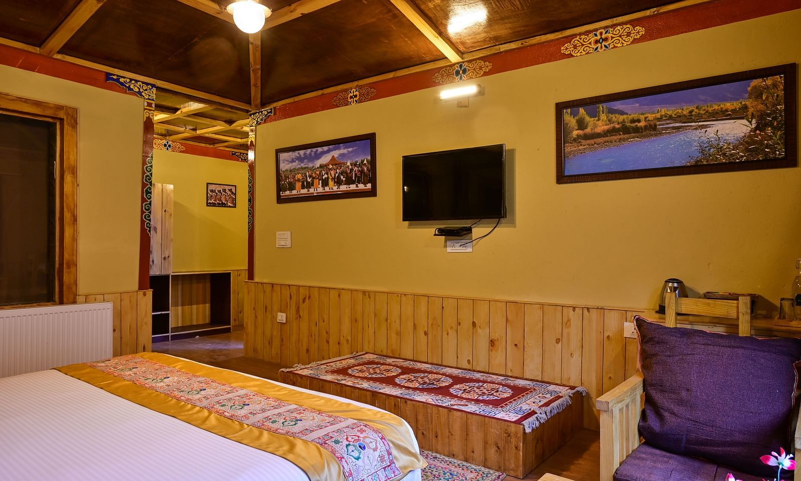 Premium Cottage in White Sands Resort, Ladakh, features a king size bed, a TV, and a comfortable seating area.
