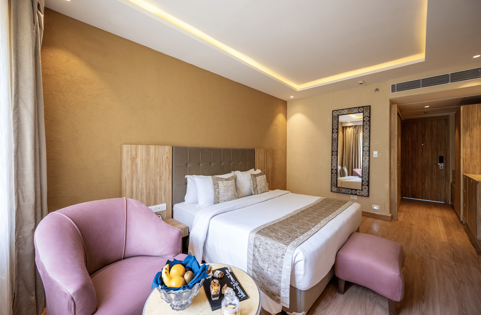 Standard Room featuring a plush bed with ottoman near a seating space with a couch and a coffee table at Essentia Luxury Resort & Spa, Udaipur