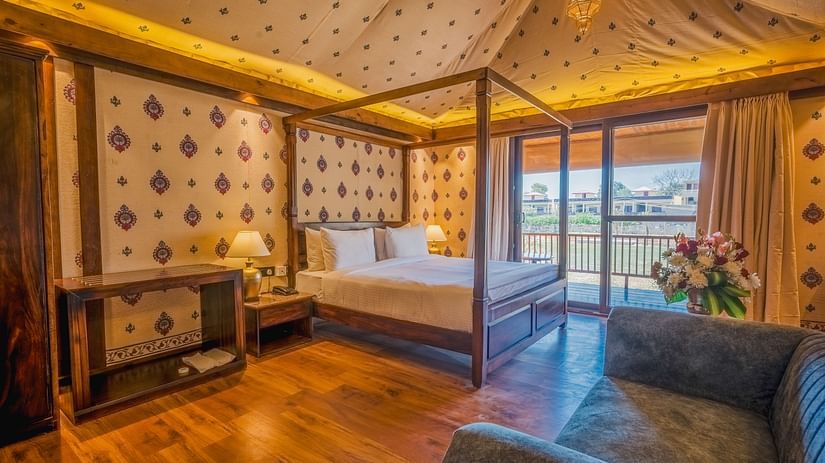 A Premium Duplex Tent featuring  a plunge swimming pool, a sofa set, with centre table, and a flight of wooden stairs at The Baagh Ananta Elite, Ranthambore