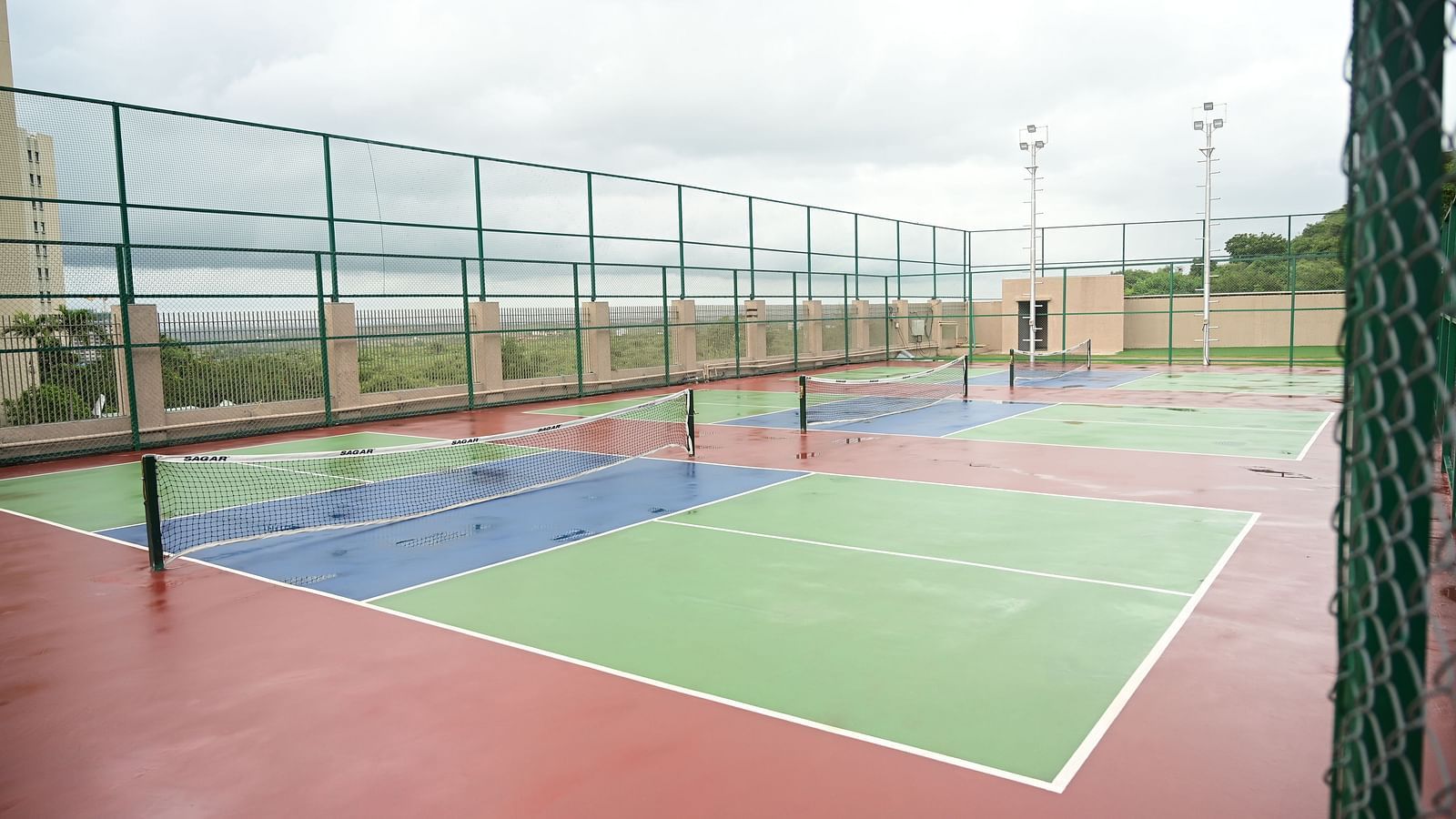 image featuring three distinct tennis courts at club charholi, pune